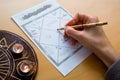 A woman's hand fills in an astrology chart of Jyotish astrology of ancient India