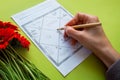 A woman's hand fills in an astrology chart of Jyotish astrology of ancient India