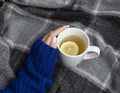 Woman& x27;s hand holding cup of tea with lemon on a cold day Royalty Free Stock Photo