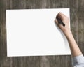 Woman's hand holding pen writing on blank white paper