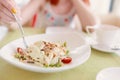 Woman's hand holds fork in a plate of salad. Royalty Free Stock Photo