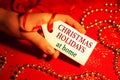 A woman's hand holds a label - Christmas Holidays at home.