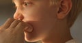 Woman's hand injects a nasal spray to a little blond boy. Hygiene procedures at home. Natural light. Close-up