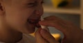 Woman's hand injects a nasal spray to a little blond boy. Hygiene procedures at home. Natural light. Close-up