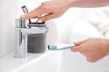 Woman& x27;S Hand Places Toothbrush Under Faucet Royalty Free Stock Photo