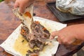 A woman& x27;s hand separates the fried meat from the bones, cutting it with a knife. Delicious meat for a family dinner