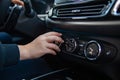 Woman& x27;s hand switches the air conditioning in the car. Driver turning on car air conditioning system. moderm climate Royalty Free Stock Photo