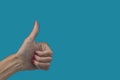Woman& x27;s hand with thumbs up. With red painted fingernails. Gesture of positive, ok, good, I like it. On light blue Royalty Free Stock Photo
