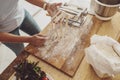 A woman& x27;s hands on the background of a wooden kitchen board hold noodles cut in a noodle cutter Royalty Free Stock Photo