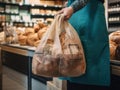 woman's hands carefully hold a craft paper bag with groceries