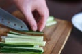 Woman& x27;s Hands Cut Cucumber Matchsticks with Santoku Knife on a Wooden Chopping Board. Salads, Maki and Temaki Sushi Rolls Royalty Free Stock Photo