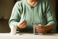 Woman& x27;s hands holds a blue capsule and glass of water over the table, ready to take medicines. Health care concept. Royalty Free Stock Photo