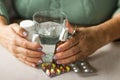 Woman& x27;s hands holds medicines - throat spray and ear spray bottles, blisters of capsules and pills and glass of Royalty Free Stock Photo