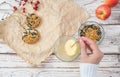 The woman& x27;s hands make food for wild birds from apple, bacon and seeds. Winter bird feeder on a white wooden background Royalty Free Stock Photo