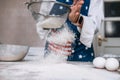 Woman& x27;s hands sifting flour through sieve. Selective focus. Royalty Free Stock Photo