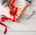 Woman's hands wrapping christmas holiday present iwith red ribbon Royalty Free Stock Photo