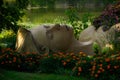 Woman's sculpture lying in the green grass surrounded by colorful trees in Biblical Garden Elgin