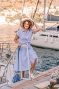 Woman yacht sea. A young happy woman in a blue dress and hat sta