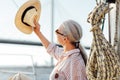 Woman on yacht uses a hat to hide her face