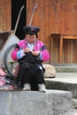 Woman of the Red Yao hill tribe in traditional costume is embroidering, Longji, China