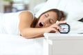 Woman yawning at wakeup turning off alarm clock Royalty Free Stock Photo