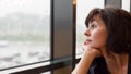 Woman 35-40 years old sadly looks at rain outside