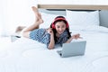 woman, 23 years old, Wears red headphones She smiles happily while using a notebook computer Royalty Free Stock Photo