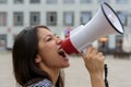 Woman yelling into a bullhorn on an urban street Royalty Free Stock Photo