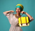 Woman yelling screaming and eating belt of hand hold stylish fashion yellow leather bag handba Royalty Free Stock Photo