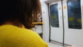 Woman in yellow blouse getting home train, monotony lifestyle, public transport