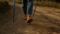 Woman in yellow boots hiking on dirt road. Front view female hiker trekking Royalty Free Stock Photo