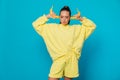 a woman in yellow clothes on a blue background with bananas in her ears Royalty Free Stock Photo