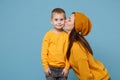 Woman in yellow clothes kissing kiss cheek cute child baby boy 4-5 years old. Mommy little kid son isolated on blue Royalty Free Stock Photo