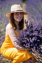 A woman in a yellow dress holds a huge bouquet of lavender flowers Royalty Free Stock Photo