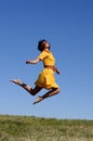 Woman in yellow dress jumping