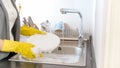 Young woman in yellow gloves applying detergent suds on dishes Royalty Free Stock Photo