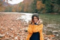 woman in yellow jacket on nature travel river autumn