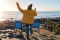 Woman in a yellow  jacket walking alone on the seaside on cold winter day. Travel Lifestyle concept Royalty Free Stock Photo