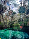 Woman in yellow-orange kayak paddling in blue spring waters, Silver Springs State Park, Florida