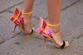 Woman with yellow and pink high heel butterfly shoes before Salvatore Ferragamo fashion show, Milan Fashion