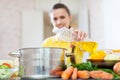 Woman in yellow pours oil from bottle