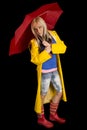 Woman in a yellow rain coat and a red umbrella on black looking Royalty Free Stock Photo