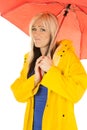 Woman in yellow rain coat under red umbrella sad