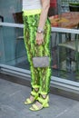 Woman with yellow reptile skin pattern and Omega watch before Palm Angels fashion show, Milan