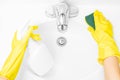 Woman in yellow rubber gloves is cleaning bathroom sink with detergent Royalty Free Stock Photo