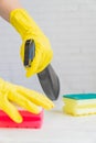 Woman  in yellow rubber gloves holding cleaning sponge.  Cleaning the white kitchen after cooking Royalty Free Stock Photo