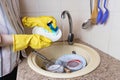 a woman in yellow rubber gloves washes dishes with a sponge in the sink in the kitchen, house cleaning, Royalty Free Stock Photo