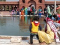 Woman in yellow sari washes her young child at jama masjid mosque in delhi Royalty Free Stock Photo