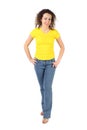 Woman in yellow shirt and jeans standing