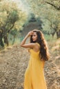 Woman in yellow summer linen dress in olive tree garden. Natural beauty Royalty Free Stock Photo